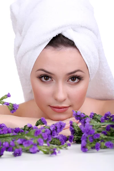 Bella giovane donna con asciugamano sulla testa e fiori isolati su bianco — Foto Stock