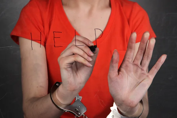 Prisoner in handcuffs behind glass in soundproof room — Stock Photo, Image