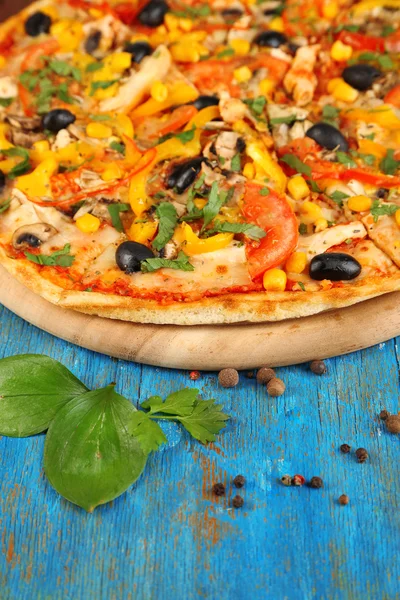 Leckere Pizza auf blauem Holztisch in Großaufnahme — Stockfoto