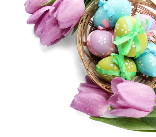 A kosár és a tulipánok, elszigetelt fehér fényes húsvéti tojás — Stock Fotó