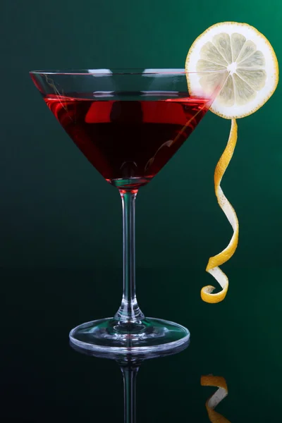 Red cocktail in martini glass on dark green background — Stock Photo, Image