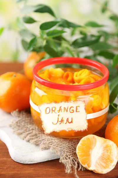 Sinaasappeljam met schil en mandarijnen, op bruin houten tafel — Stockfoto