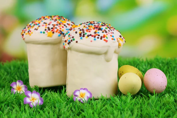 Easter cake with sugar glaze and eggs on grass — Stock Photo, Image