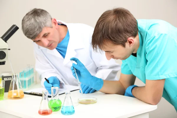 Physician and assayer during research on room background — Stock Photo, Image