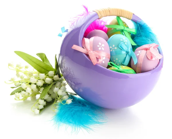 Beautiful easter eggs in basket and lilies of the valley, isolated on white — Zdjęcie stockowe