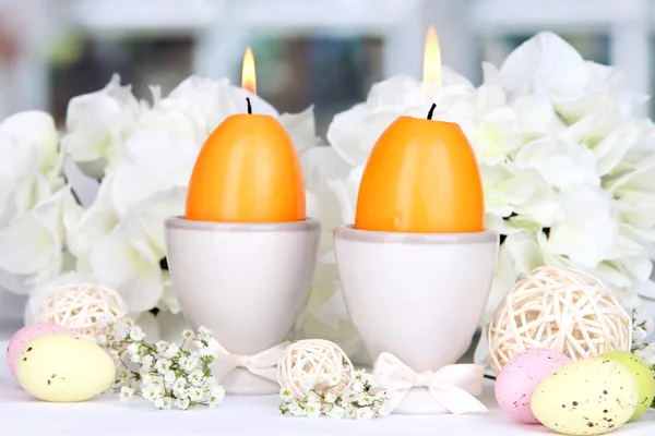 Easter candles with flowers on window background — Stock Photo, Image