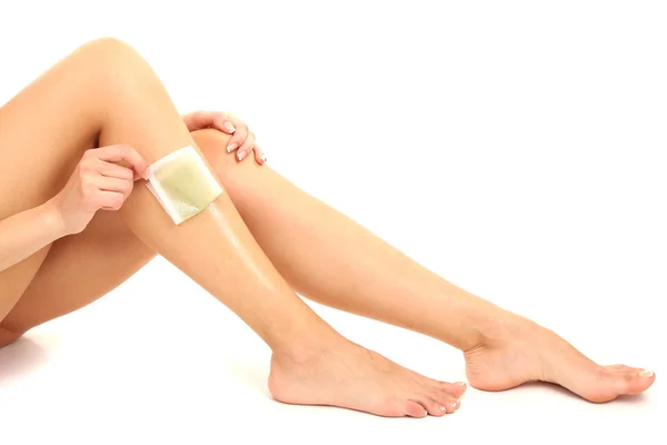Krásná žena dělá depilace za její nohy s voskování, izolovaných na bílém — Stock fotografie