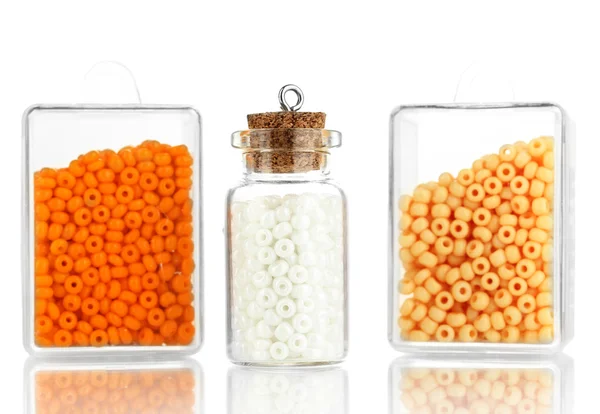Bunte Perlen stapeln sich in Schachteln und Glasflaschen isoliert auf weiß — Stockfoto