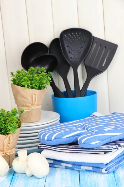 Kitchen settings: utensil, potholders, towels and else on wooden table — Stock Photo, Image