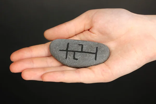 Fortune telling with symbols on stone in hand on grey background — Stock Photo, Image