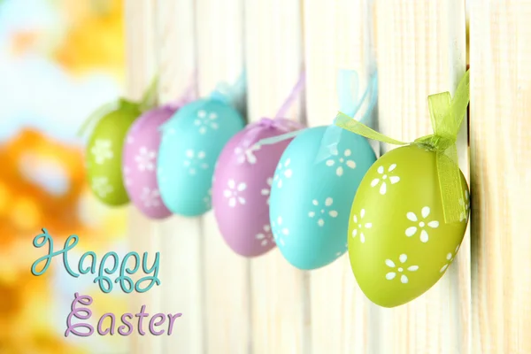 Kunst Ostern Hintergrund mit Eiern hängen am Zaun lizenzfreie Stockbilder