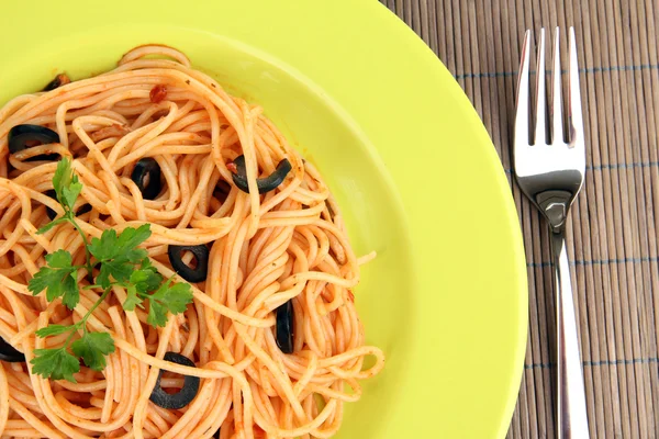 Espaguetis italianos en plato sobre alfombra de bambú de cerca — Foto de Stock