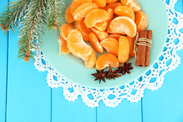Välsmakande mandarine skivor på färgplåt på blå bakgrund — Stockfoto