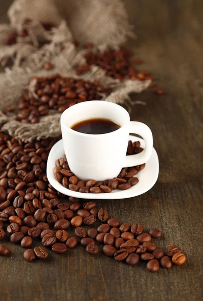 Tazza di caffè e chicchi di caffè su sfondo di legno — Foto Stock