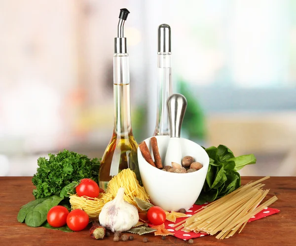 Composition of mortar, pasta and green herbals, on bright background — Stock Photo, Image