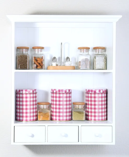 Hermosos estantes blancos con especias en botellas de vidrio — Foto de Stock