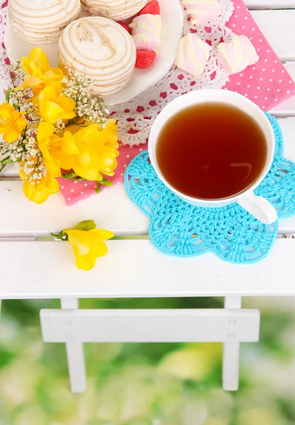 Beautiful composition with cup of tea and marshmallow on wooden picnic table close-up — Stock Photo, Image