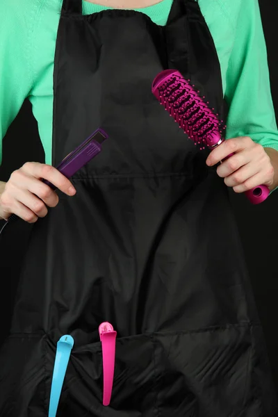 Hairdresser in uniform with working tools, isolated on black — Stock Photo, Image