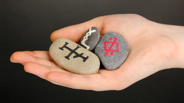 Fortune telling with symbols on stone in hand on grey background — Stock Photo, Image