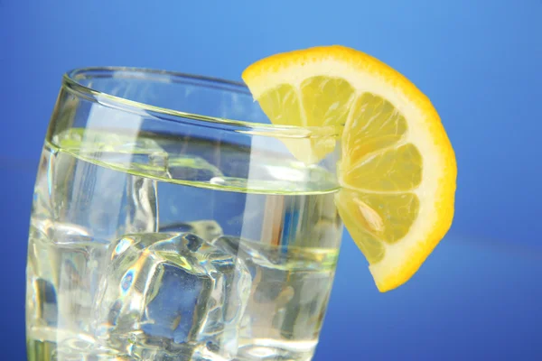 Bicchiere di acqua e ghiaccio su sfondo blu — Foto Stock