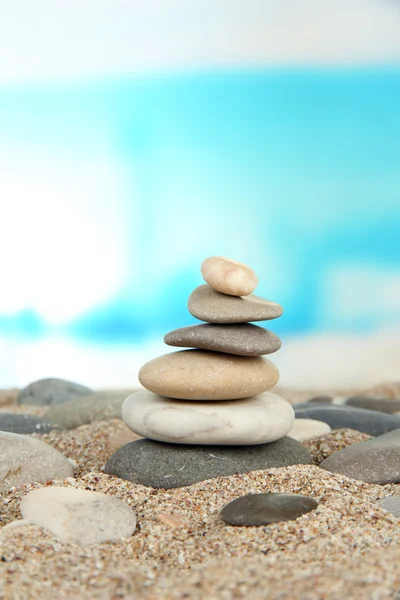 Tower of sea stones on sand on bright background — Stock Photo, Image