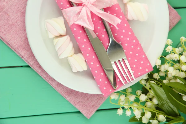 Tischdekoration in weißen und rosa Tönen auf farbigem Holzhintergrund lizenzfreie Stockfotos