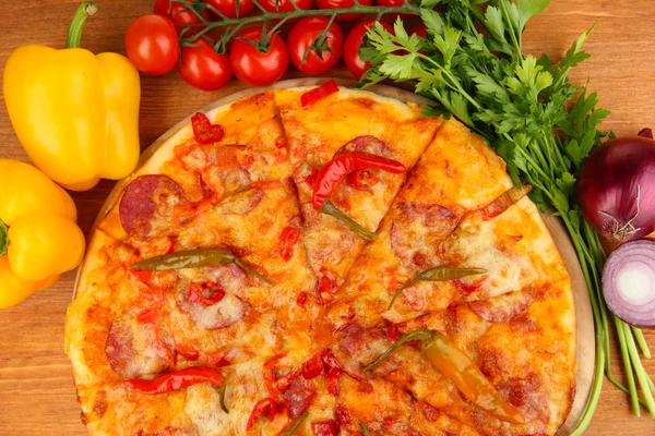 Välsmakande pepperoni pizza med grönsaker på träplatta på trä bakgrund — Stockfoto