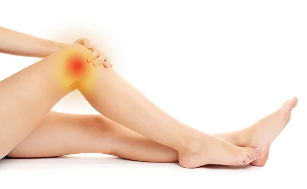 Mujer sosteniendo dolor de rodilla, aislado en blanco —  Fotos de Stock