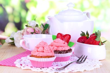 güzel çilekli kek ve doğal zemin üzerine yemek masası üzerinde aromalı çay