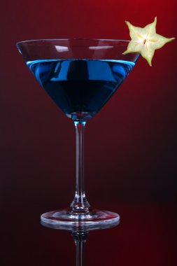 kokteyl martini bardağına koyu kırmızı zemin üzerine mavi