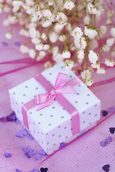 Flores y caja de regalo sobre fondo rosa —  Fotos de Stock