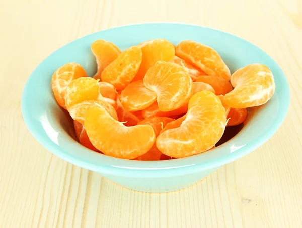 Tasty mandarine's slices in color bowl on light background — Stock Photo, Image