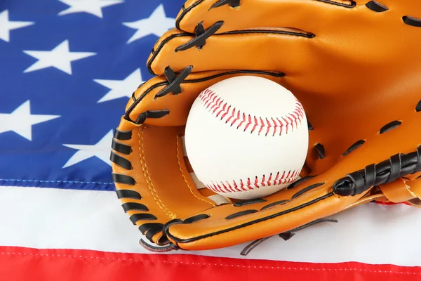 Guante de béisbol y pelota sobre fondo de bandera estadounidense — Foto de Stock