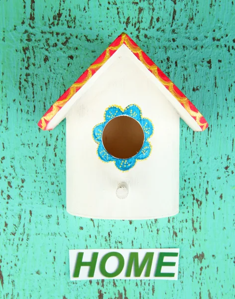 Decorative nesting box and sign on color background — Stock Photo, Image