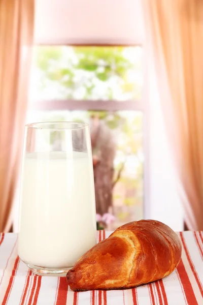 Croissant y vaso de leche en el fondo de la habitación — Foto de Stock