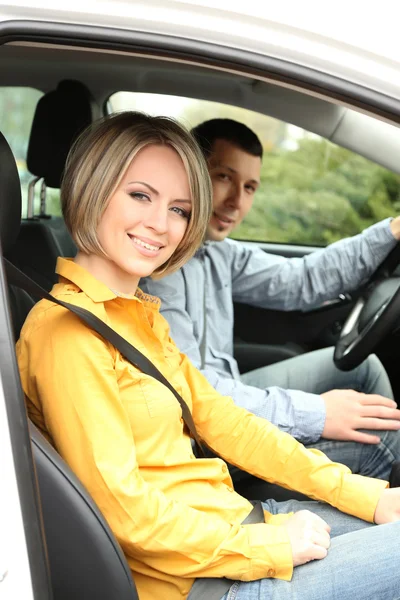 Portrait of young beautiful couple sitting in the car — Stock Photo, Image