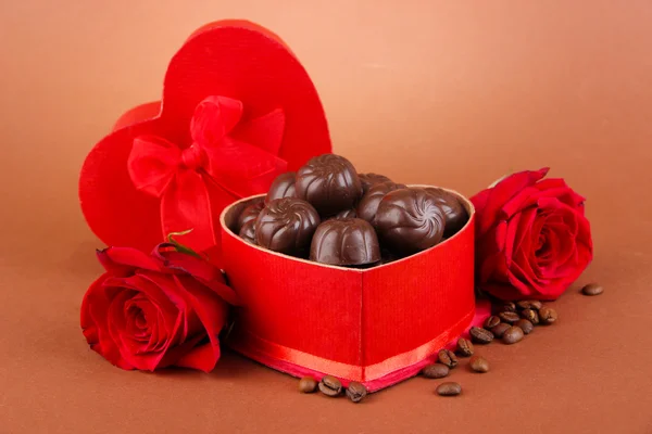 Шоколадные конфеты в подарочной коробке, на коричневом фоне — стоковое фото