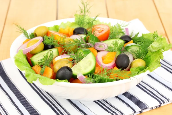 Insalata fresca in piatto su tavolo di legno — Foto Stock