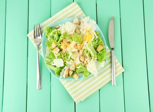 Salada Caesar na placa azul, na cor de fundo de madeira — Fotografia de Stock