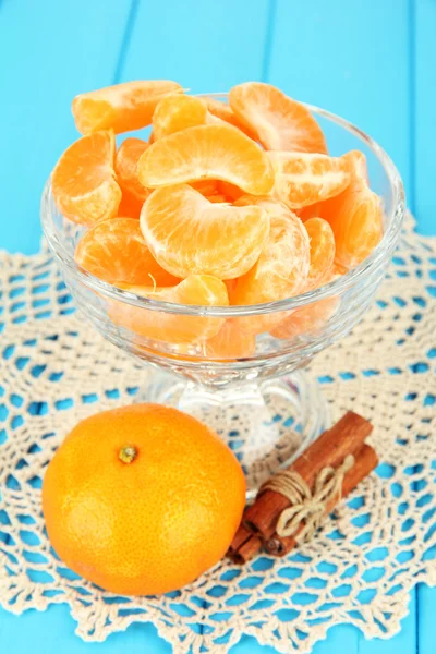 Sabrosas rebanadas de mandarina en tazón de vidrio sobre fondo azul — Foto de Stock