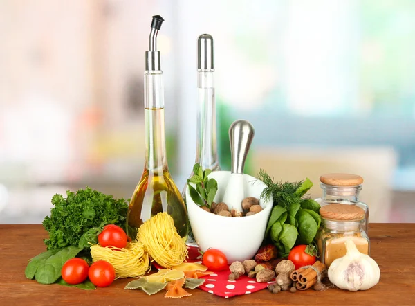 Composition of mortar, pasta and green herbals, on bright background — Stock Photo, Image