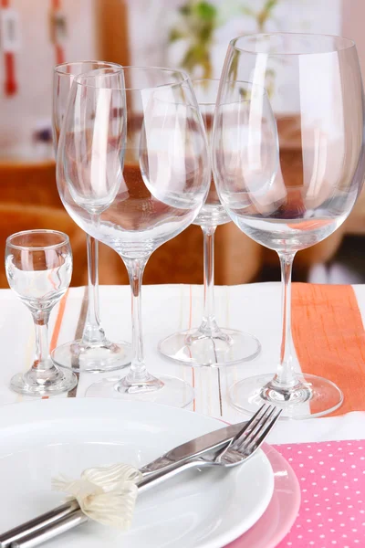 Ajuste de mesa con vasos para diferentes bebidas en la mesa sobre el fondo de la habitación — Foto de Stock