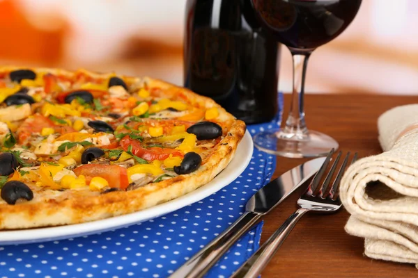 Leckere Pizza mit Wein auf Holztisch auf Zimmerhintergrund Nahaufnahme — Stockfoto