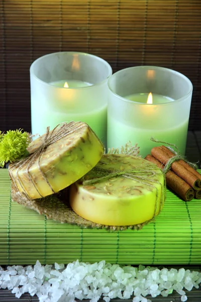 Sapone fatto a mano e candele su sfondo tappetino di bambù — Foto Stock
