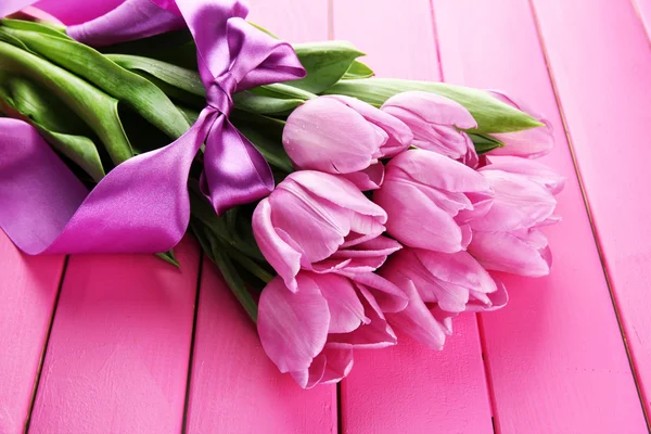 Beau bouquet de tulipes violettes sur fond de bois rose — Photo