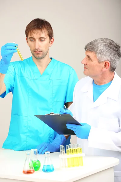 Médico y ensayador durante la investigación sobre el fondo de la habitación —  Fotos de Stock