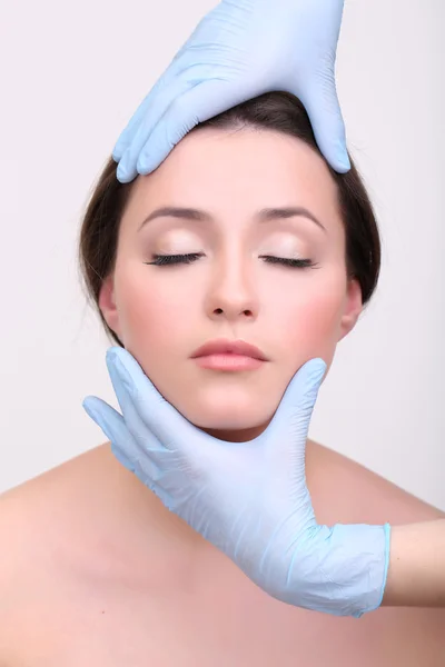 Rubber gloves touching face of young woman close up — Stock Photo, Image