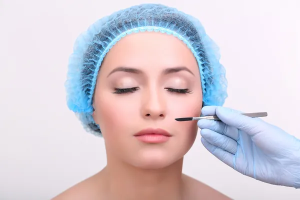 Cosmetic surgery with scalpel on young woman close up — Stock Photo, Image