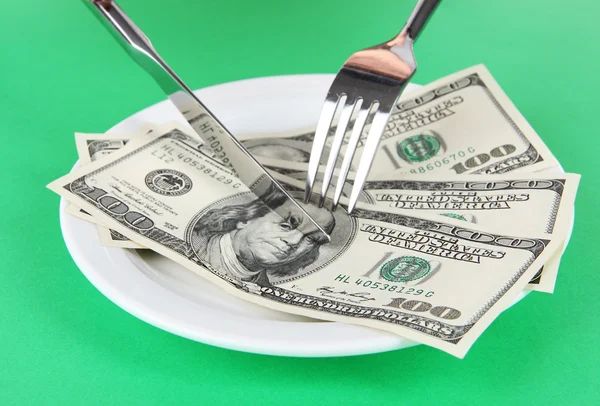 Dinero en plato sobre fondo verde — Foto de Stock