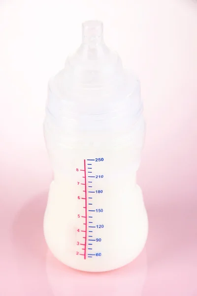 Bottiglia per latte in formula su sfondo rosa — Foto Stock